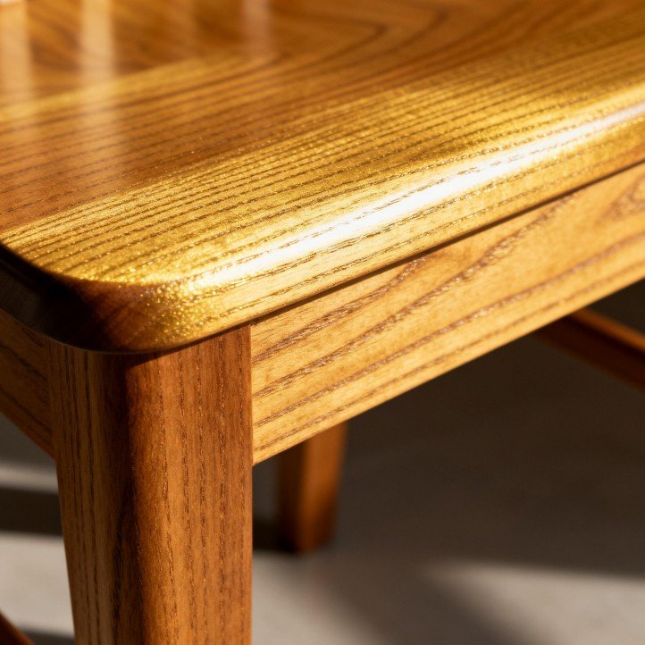 Teak dining chair close-up, natural golden tone and fine grain texture