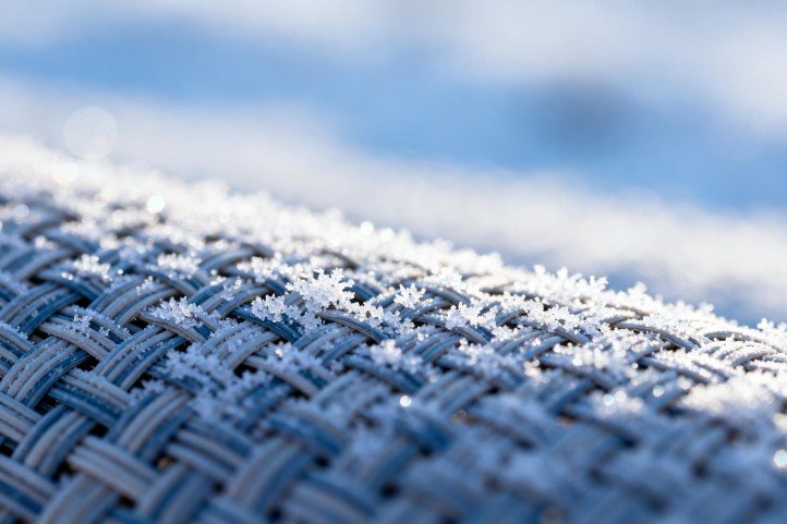 All-weather PE rattan weave with light frost, showing winter suitability when paired with breathable covers