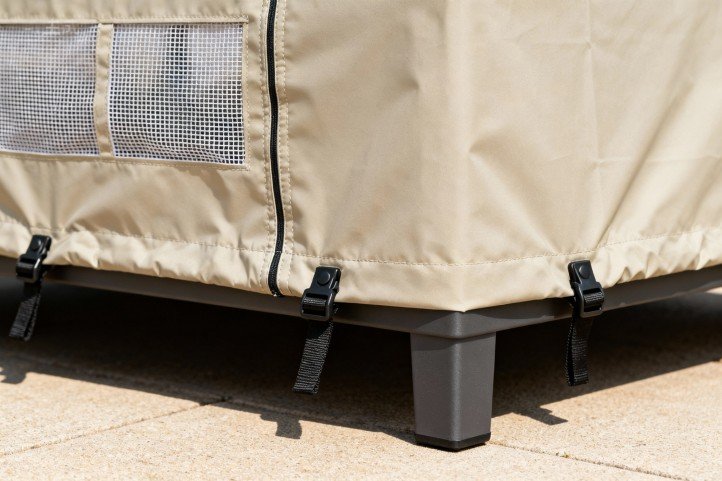 Outdoor furniture cover details—mesh vents, taped seams, buckles, and under-leg tie-down straps for wind security.